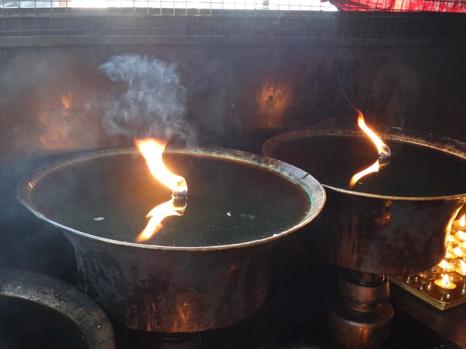 Candele bruciano in una teglia calda all'interno di un ambiente interno.
