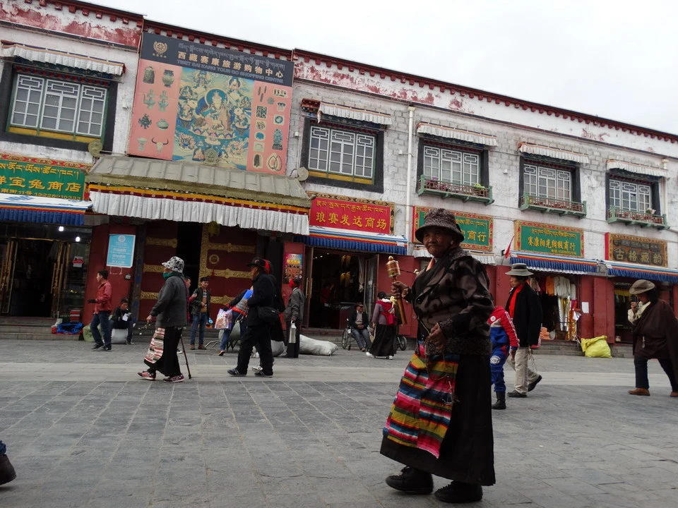 Una scena di strada con edifici tradizionali in Tibet o Kathmandu e persone che passeggiano.