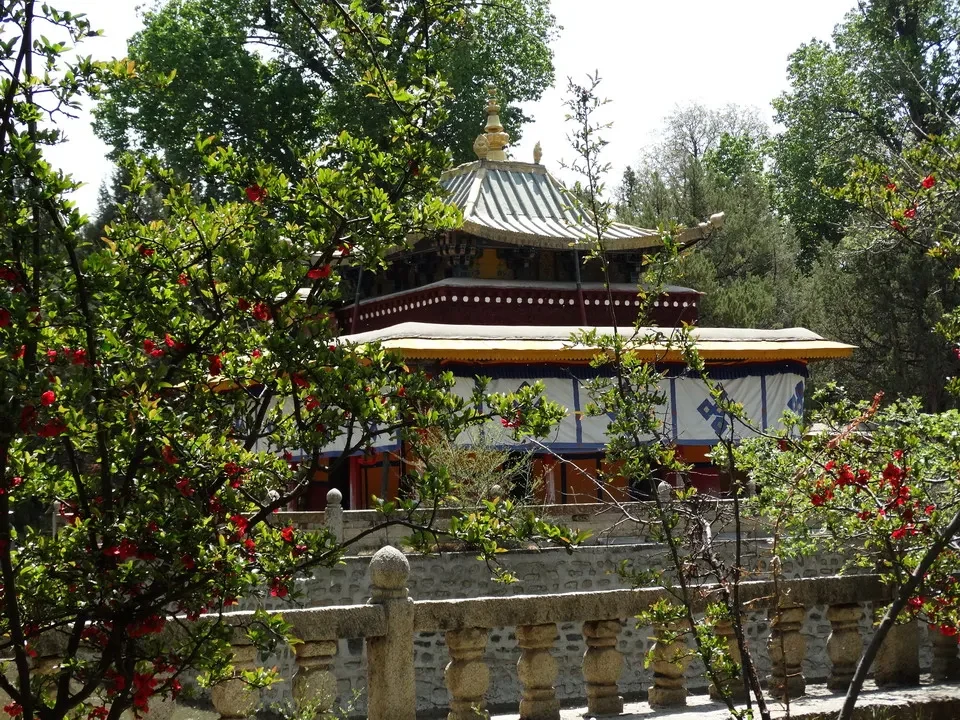 Vista del monastero di Norbulingka a Lhasa con alberi in primo piano.