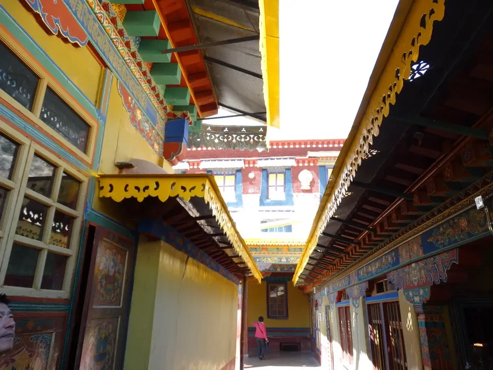 Corridoio colorato di un monastero tibetano a Lhasa con dettagli architettonici ricchi.