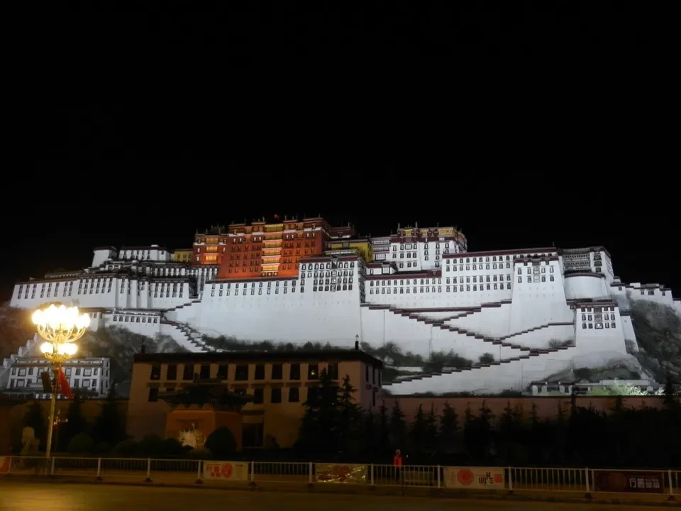 Il palazzo del Potala a Lhasa illuminato di notte mostra una vista notturna della residenza.