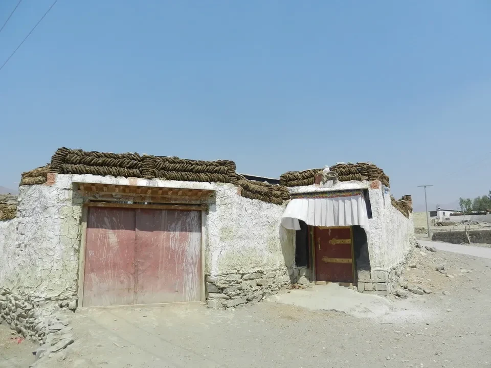 Un edificio rustico in stile tibetano con un tetto di paglia si trova vicino al Kailash.
