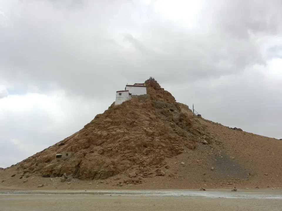 Un monastero bianco sorge su un terreno arido in Tibet vicino a Kailash.