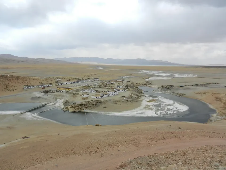 Paesaggio del Manasarovar e Chugompa con strutture lungo il fiume.