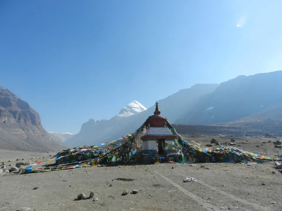 Un tempio colorato si staglia su un paesaggio montano vasto.