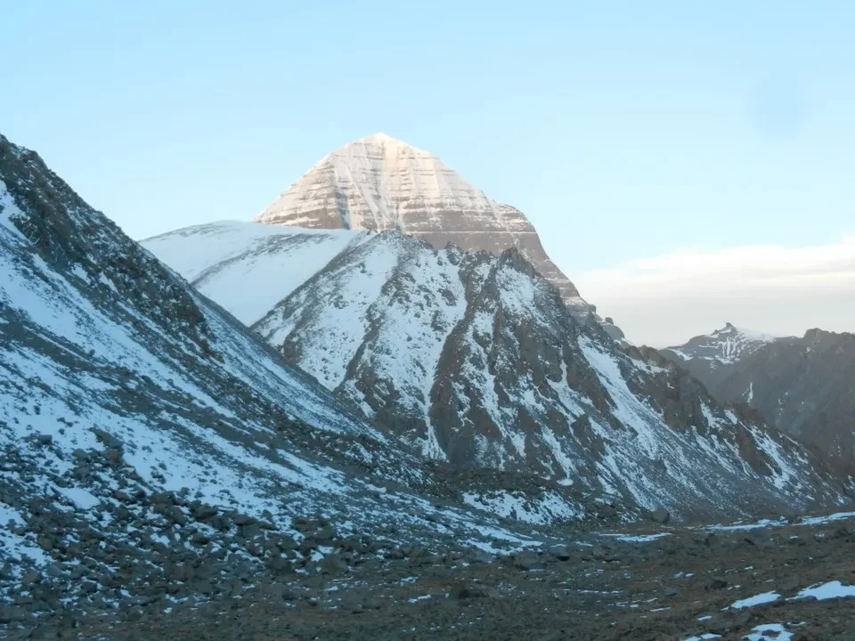 Paesaggio montano innevato con il Monte Kailash sullo sfondo.