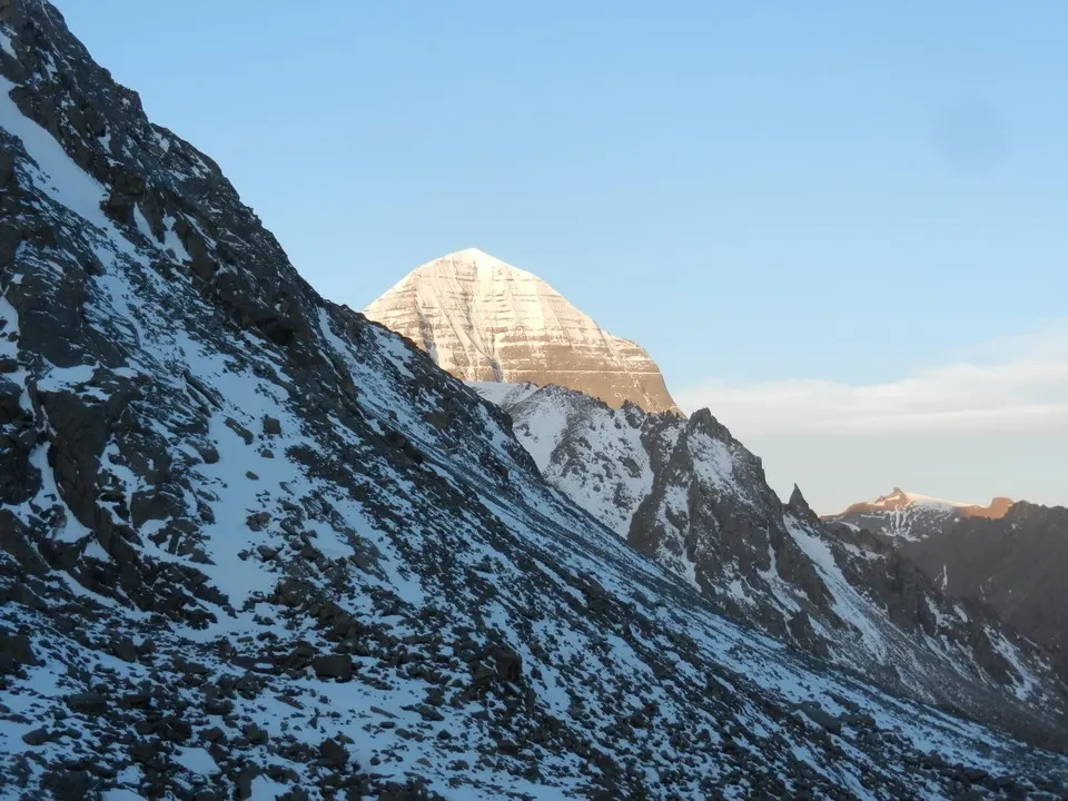 Una montagna innevata si staglia contro il cielo azzurro.