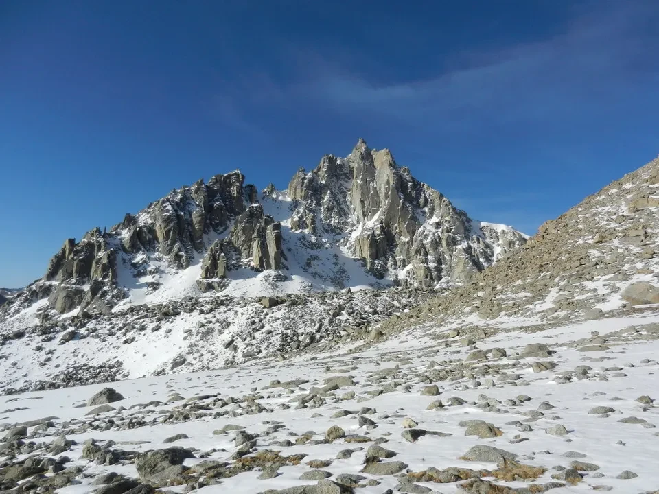 Montagne rocciose innevate con il Monte Kailash sullo sfondo.