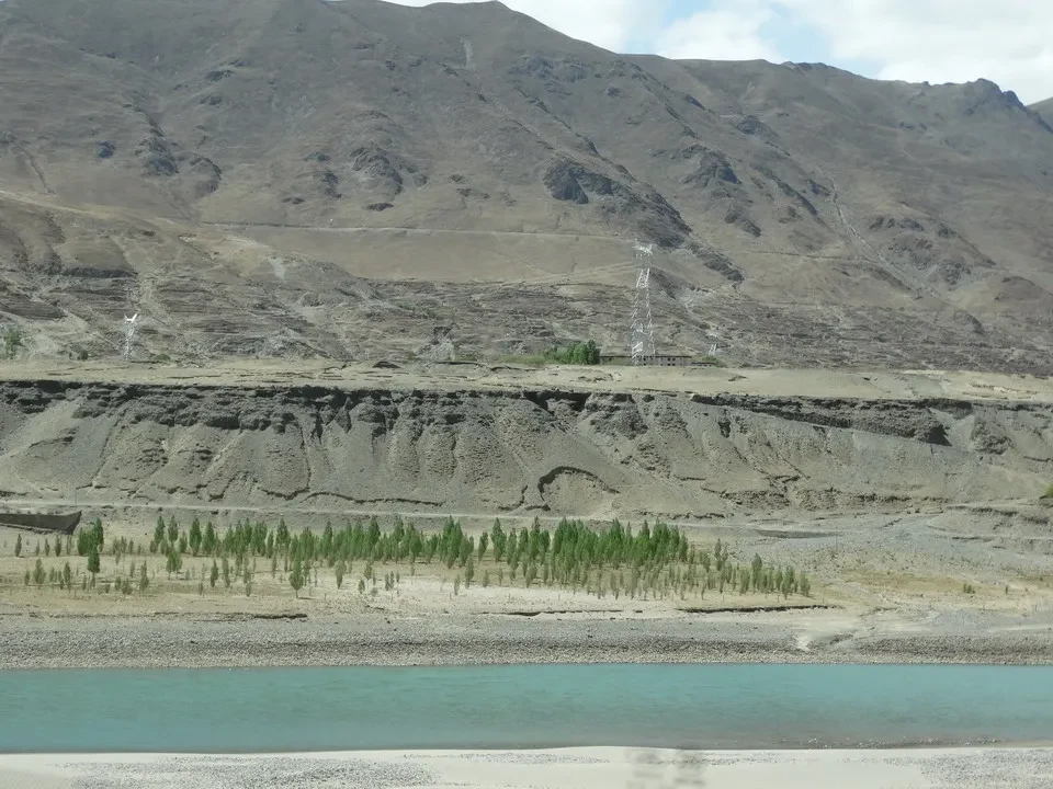 Paesaggio montano del Tibet con un fiume in primo piano.