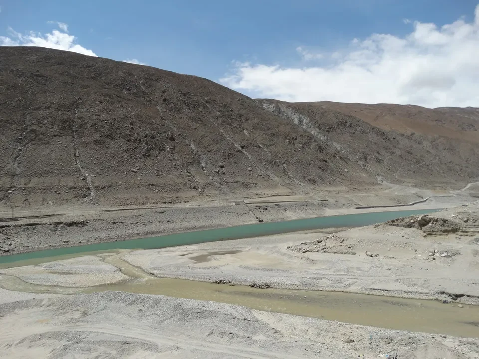 A rio scorre attraverso un paesaggio montano arido in Tibet vicino a Kailash.