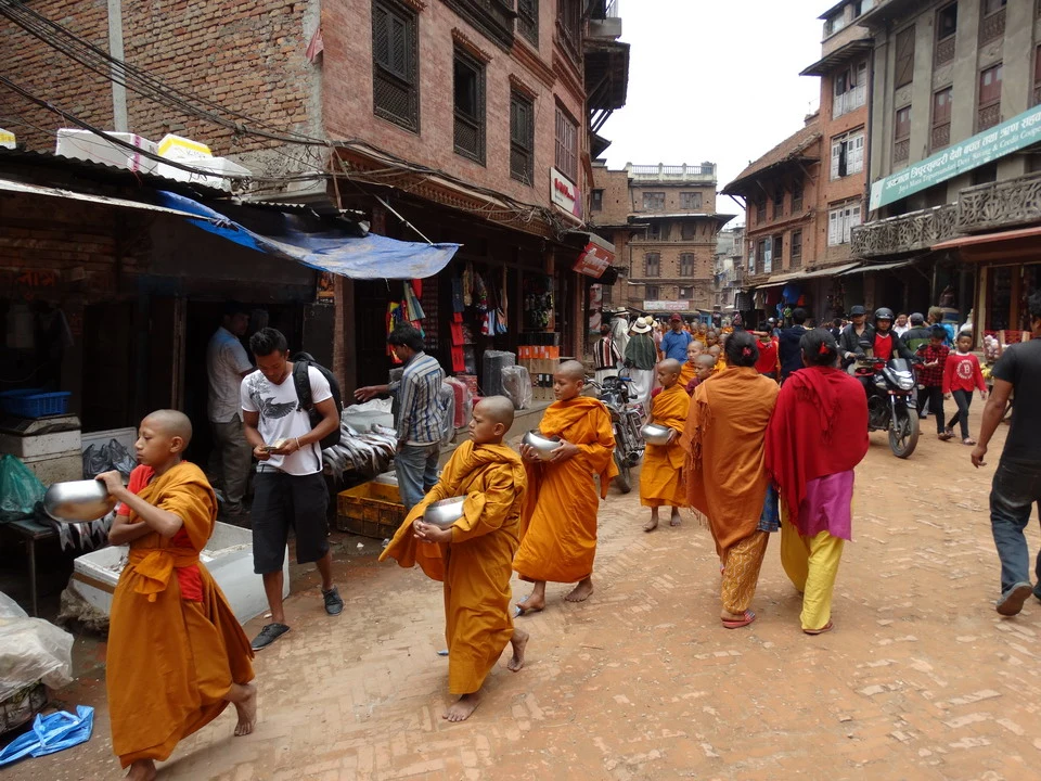 Sadhus walk through a narrow street in a Tibetan-influenced town. Sadhus walk through a narrow street in a Tibetan-influenced town.