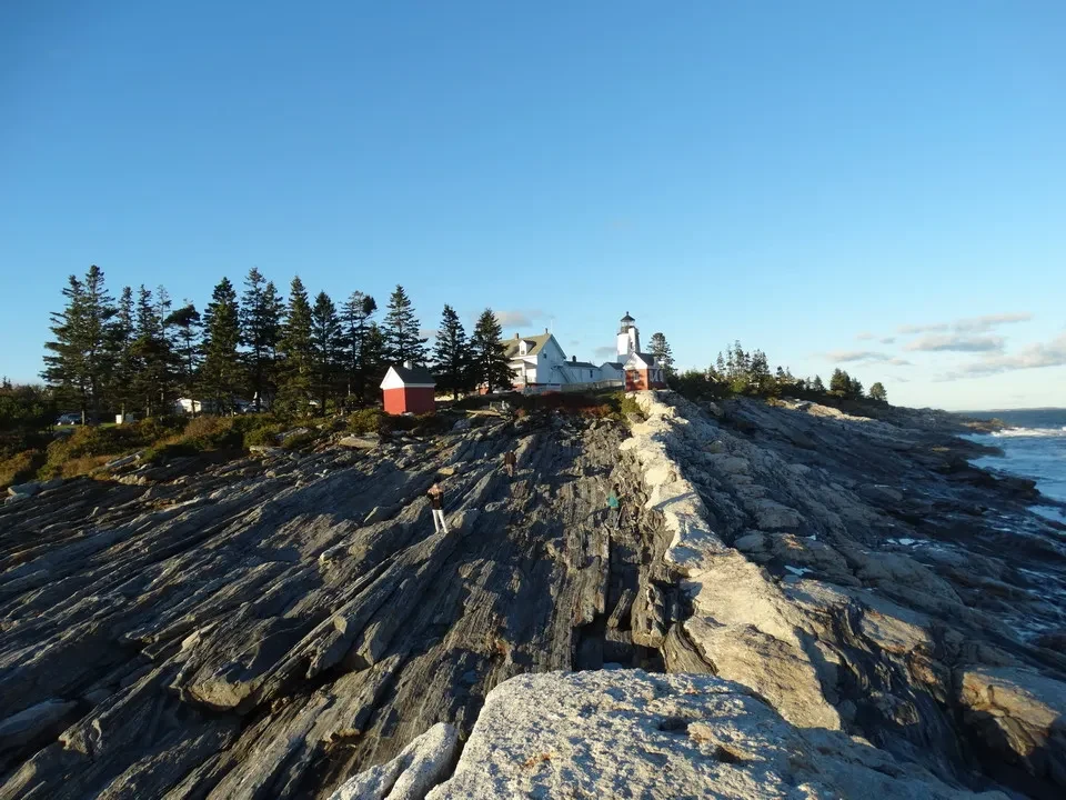 Una vista panoramica della penisola di Pemaquid nel New England con edifici bianchi e alberi lungo la costa.