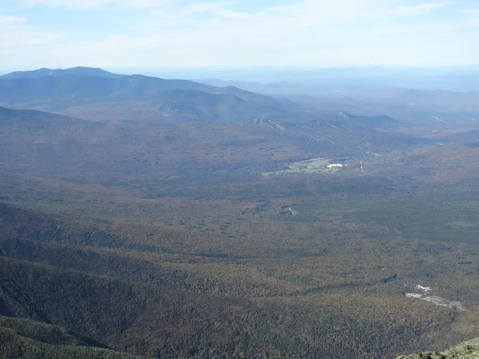 Paesaggio montano del New England con foreste estese sotto un cielo sereno.