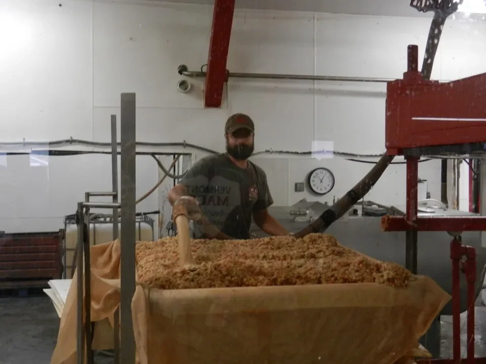 Un uomo lavora con il legno in una struttura industriale per la produzione di sidro.