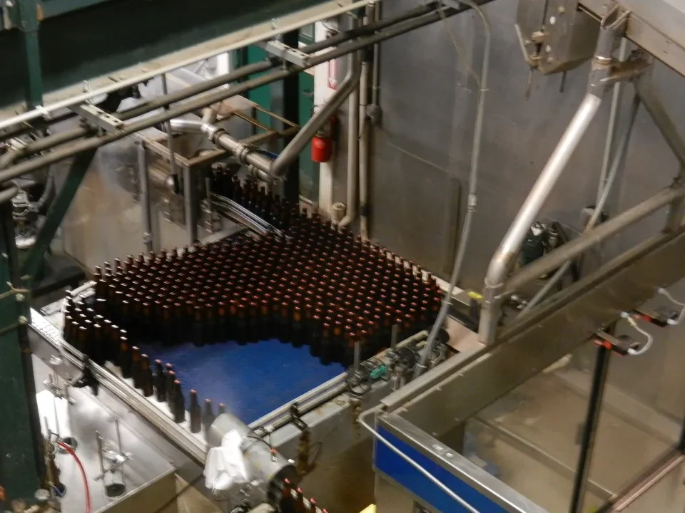 Una vista ravvicinata di una linea di bottiglie in un impianto di produzione artigianale.