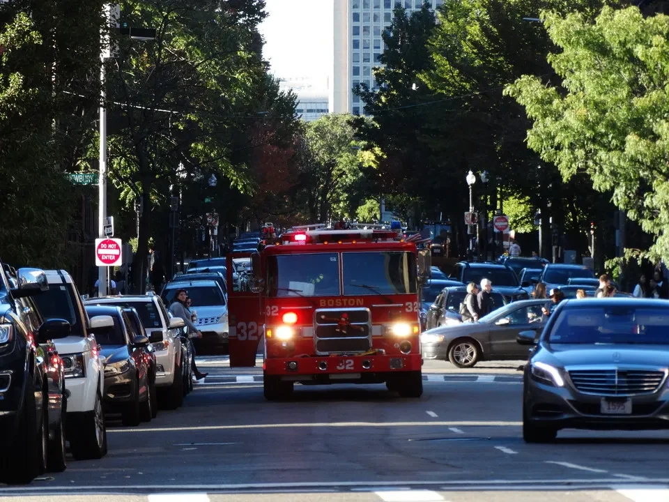 Una strada trafficata a Boston con veicoli e alberi lungo il bordo.
