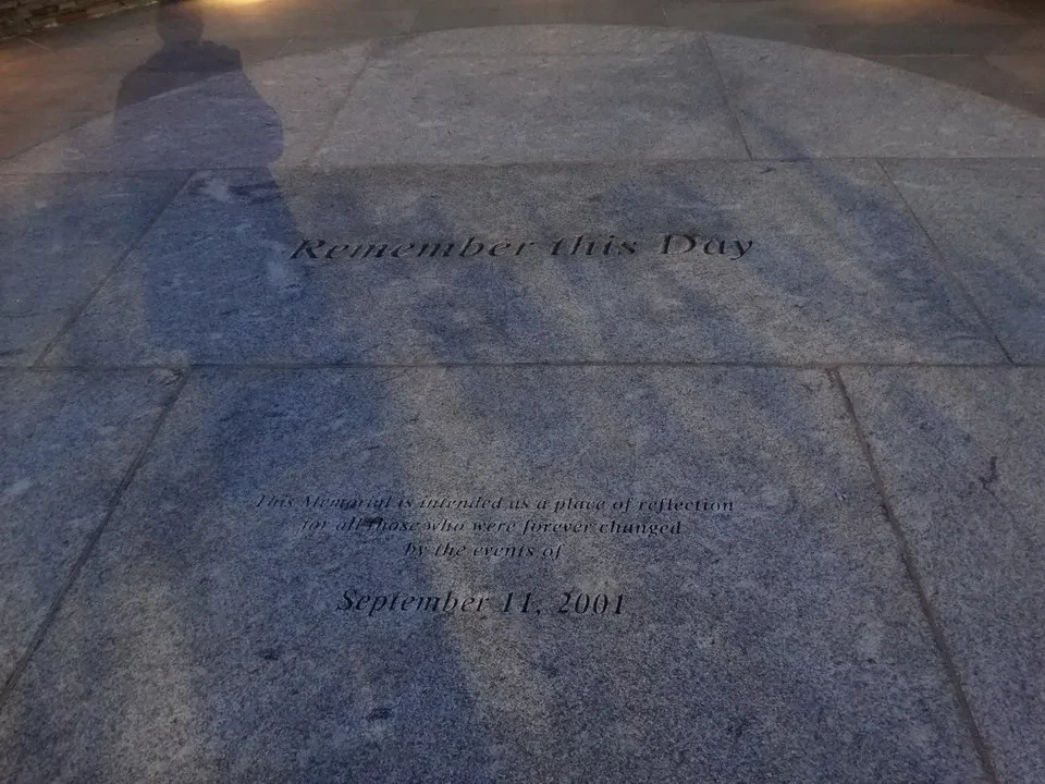 Ombra di una persona proiettata su una targa commemorativa del giorno del ricordo.