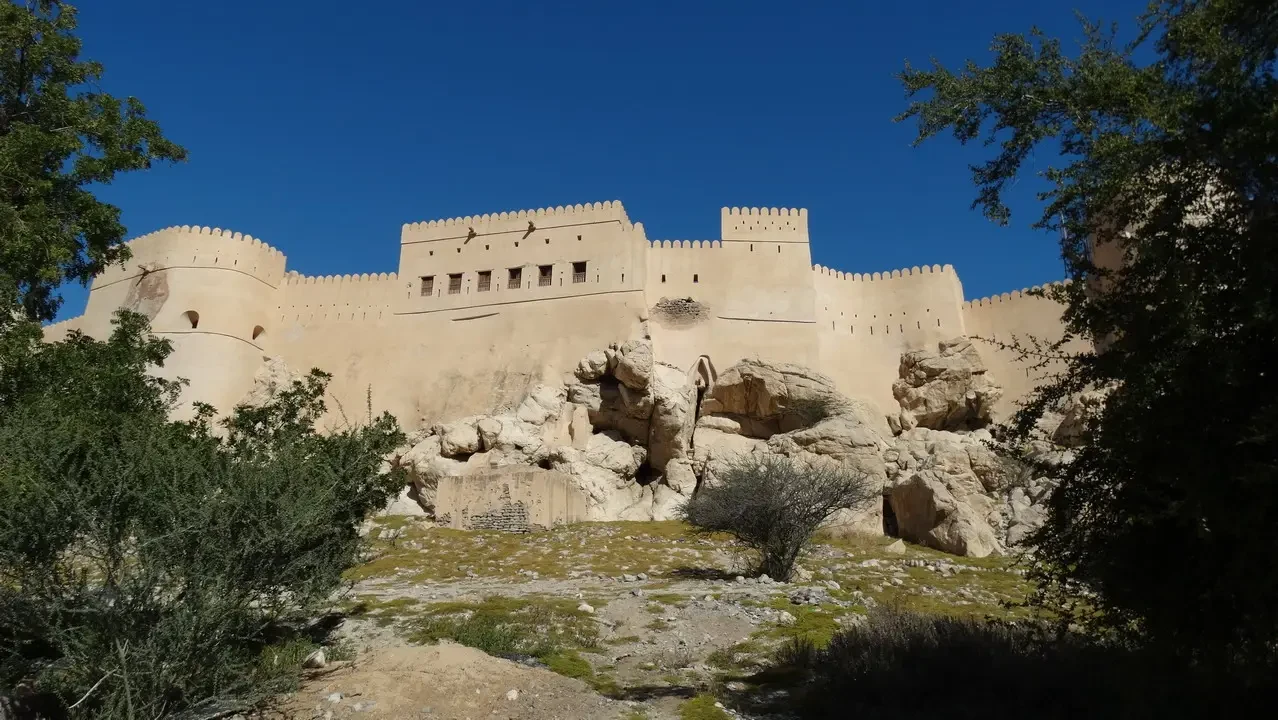 Mura murate di un castello in pietra sotto il cielo blu.
