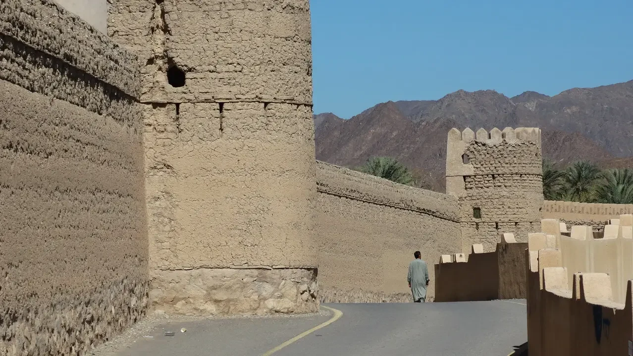 Castello di Rustaq in Oman con mura antiche e paesaggio arido.