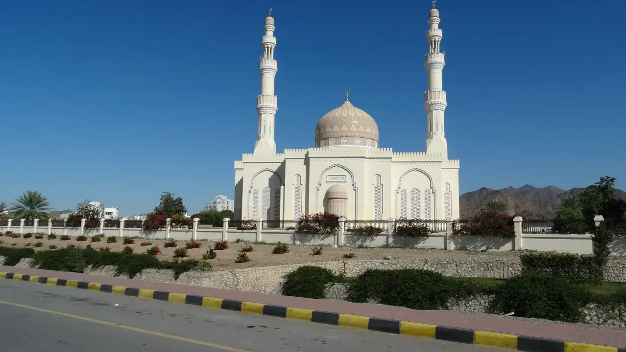 Una moschea bianca con minareti si staglia lungo la strada. Una moschea bianca con minareti si staglia lungo la strada.