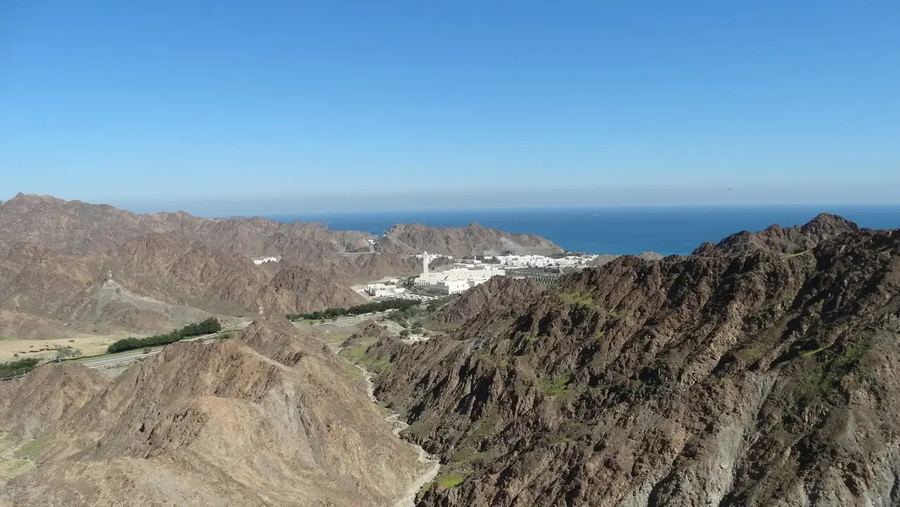 Montagne aride costiere dell'Oman con il mare sullo sfondo.