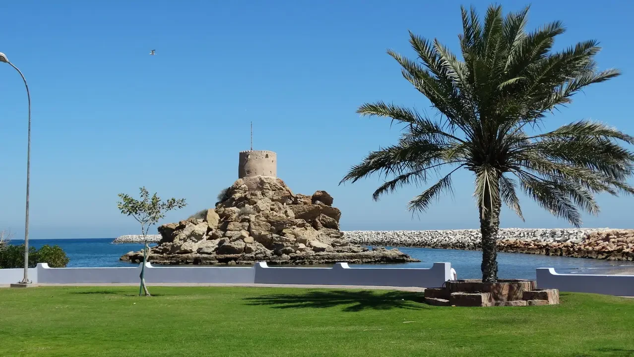Una torre antica sorge su un promontorio roccioso vicino al mare.