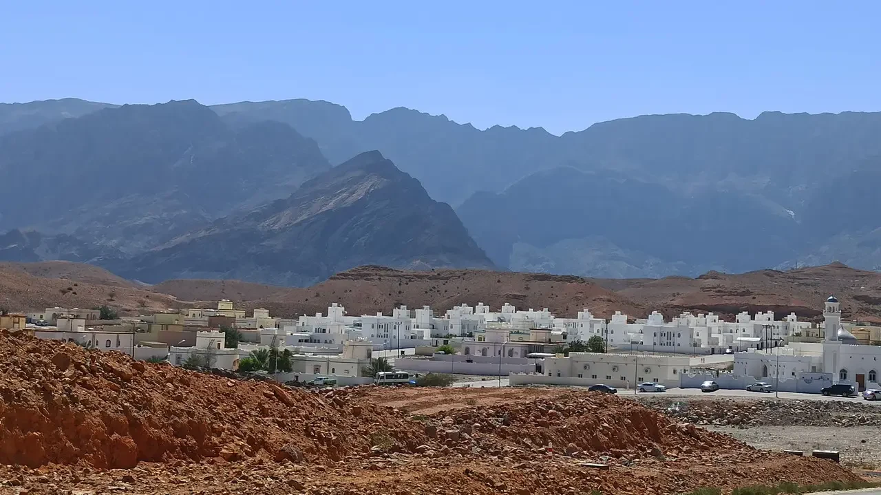 Paesaggio urbano con montagne sullo sfondo in Oman o Emirati Arabi Uniti.