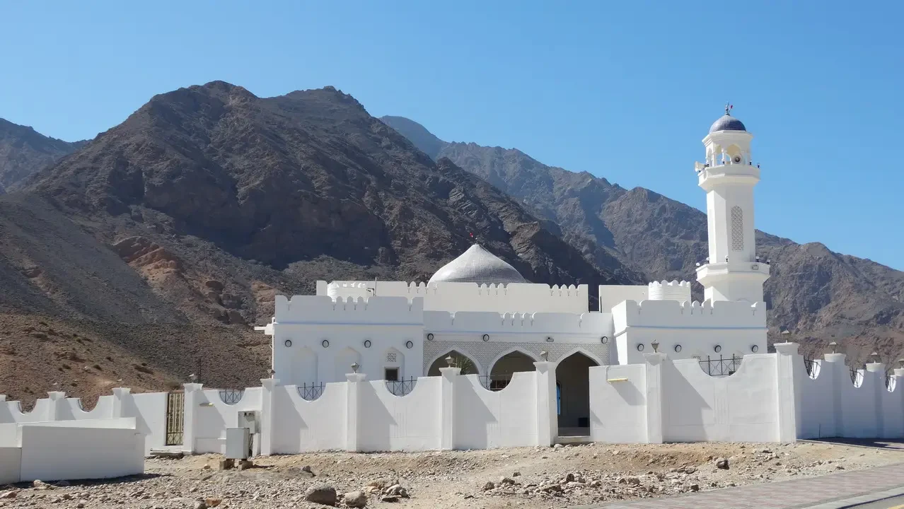Architettura bianca tradizionale in un paesaggio montuoso desertico.