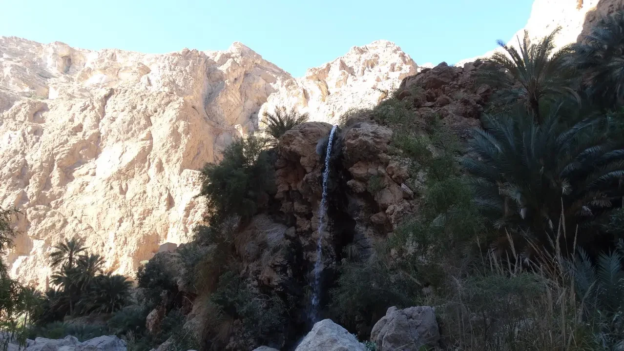 Una cascata scorre su una parete rocciosa nel deserto dell'Oman.