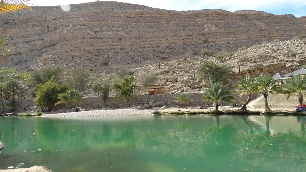 Un fiume verde scorre attraverso un paesaggio arido con vegetazione lussureggiante lungo la riva. Un fiume verde scorre attraverso un paesaggio arido con vegetazione lussureggiante lungo la riva.