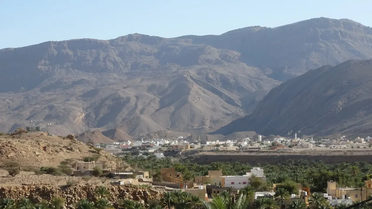 Paesaggio montuoso della regione di Dawwah in Oman con insediamenti sottostanti.