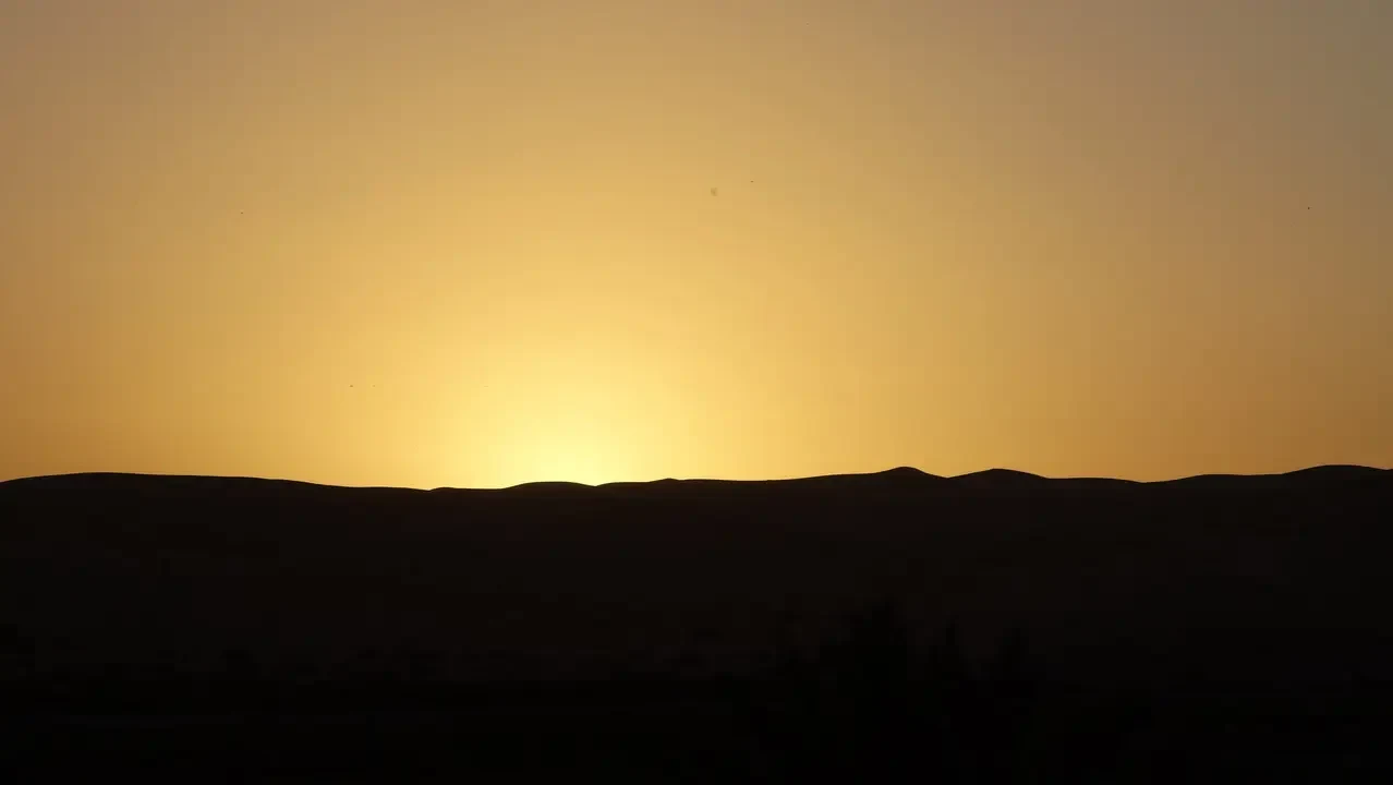 Paesaggio desertico all'alba o al tramonto con dune silenziose.