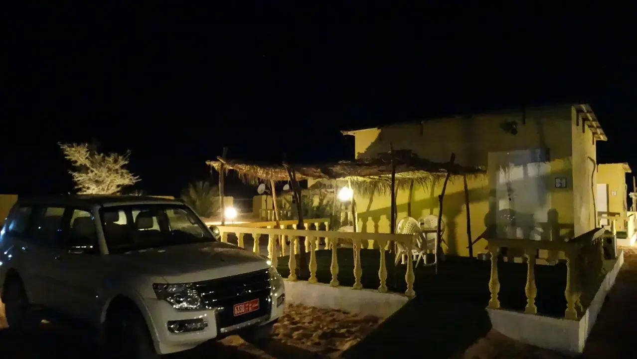 Un campo da campeggio con tende illuminato di notte nel deserto dell'Oman.