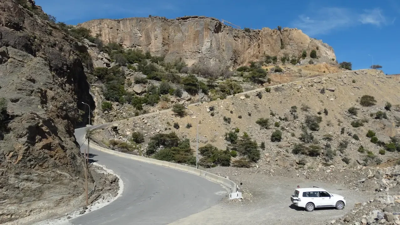 Una strada sinuosa attraversa un paesaggio roccioso in Oman o Emirati Arabi Uniti.