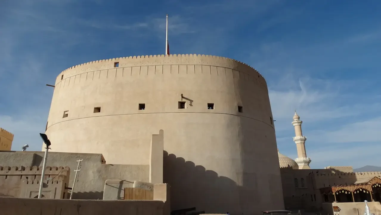 Una fortezza di colore chiaro si staglia contro il cielo azzurro in Oman.