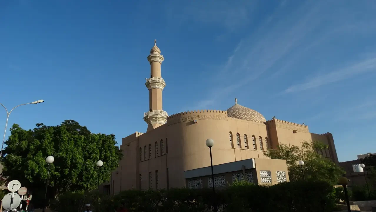 Vista esterna di un edificio religioso in stile omanita sotto il cielo azzurro.
