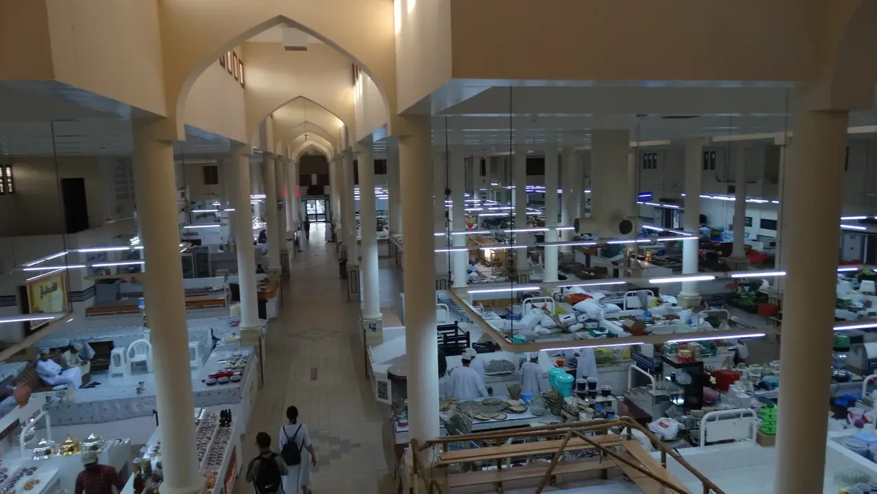 Una galleria commerciale interna con archi che conduce a diverse sezioni di vendita.