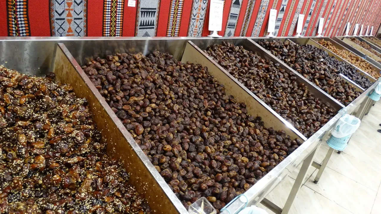 Una galleria di frutta secca esposte su scaffali metallici in un negozio.