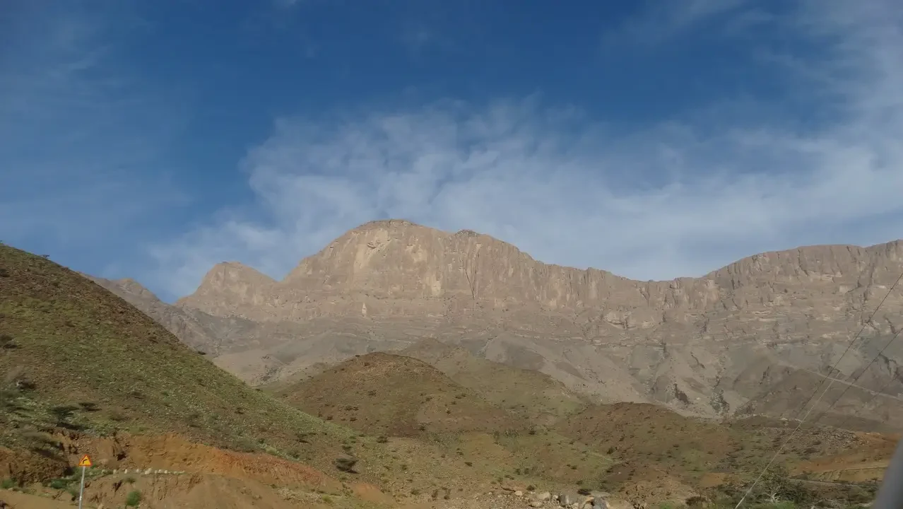 Paesaggio montuoso e arido sotto un cielo azzurro.