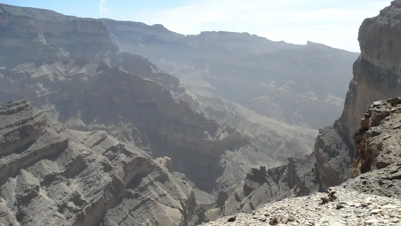 Paesaggio montuoso e roccioso nel deserto di Oman con formazioni rocciose imponenti.