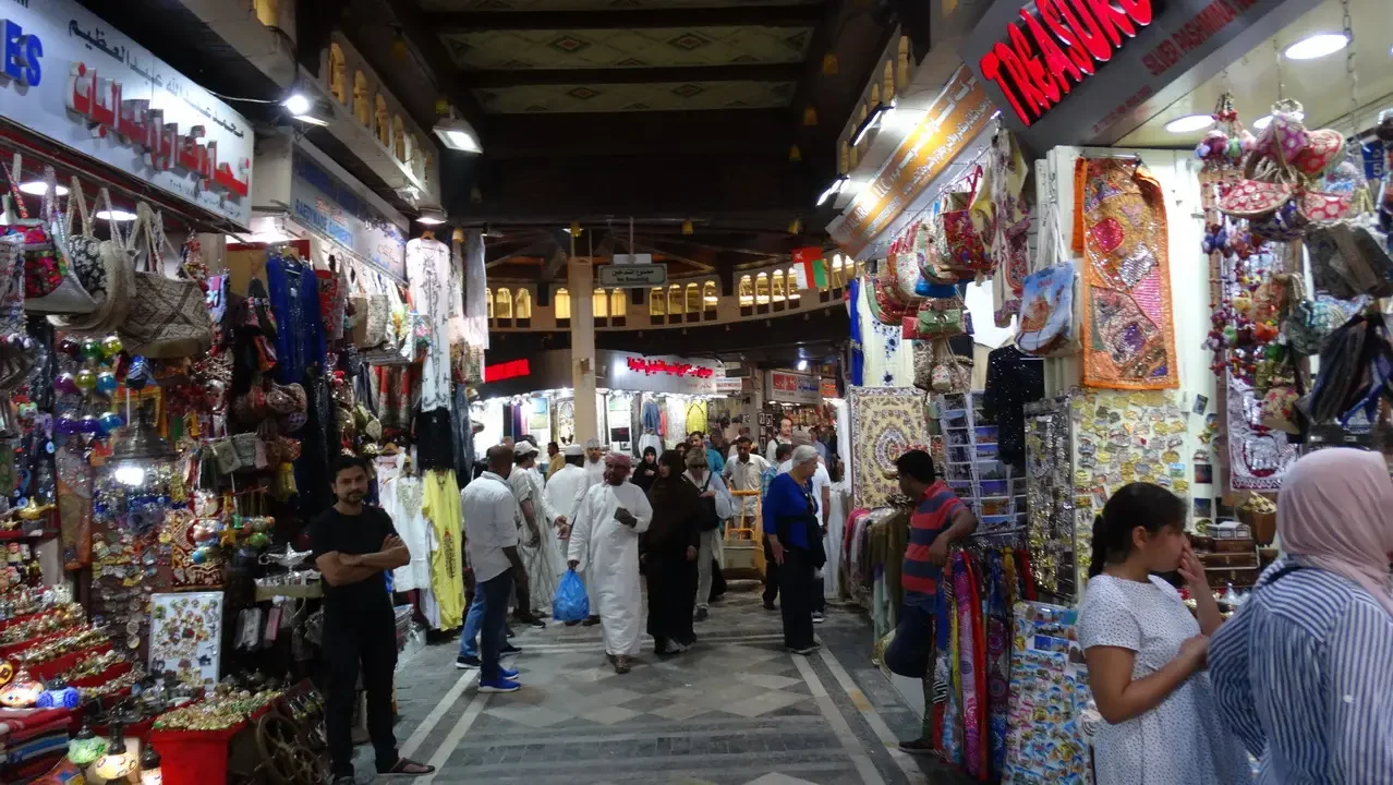 Una vista interna del souk di Mutrah a Oman, con negozi affollati e persone che passeggiano.