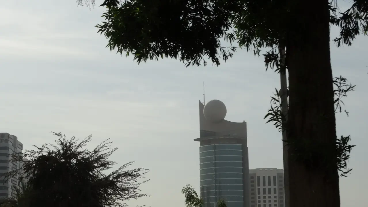 L'edificio dell'ufficio postale di Abu Dhabi è visibile sopra la linea degli alberi.