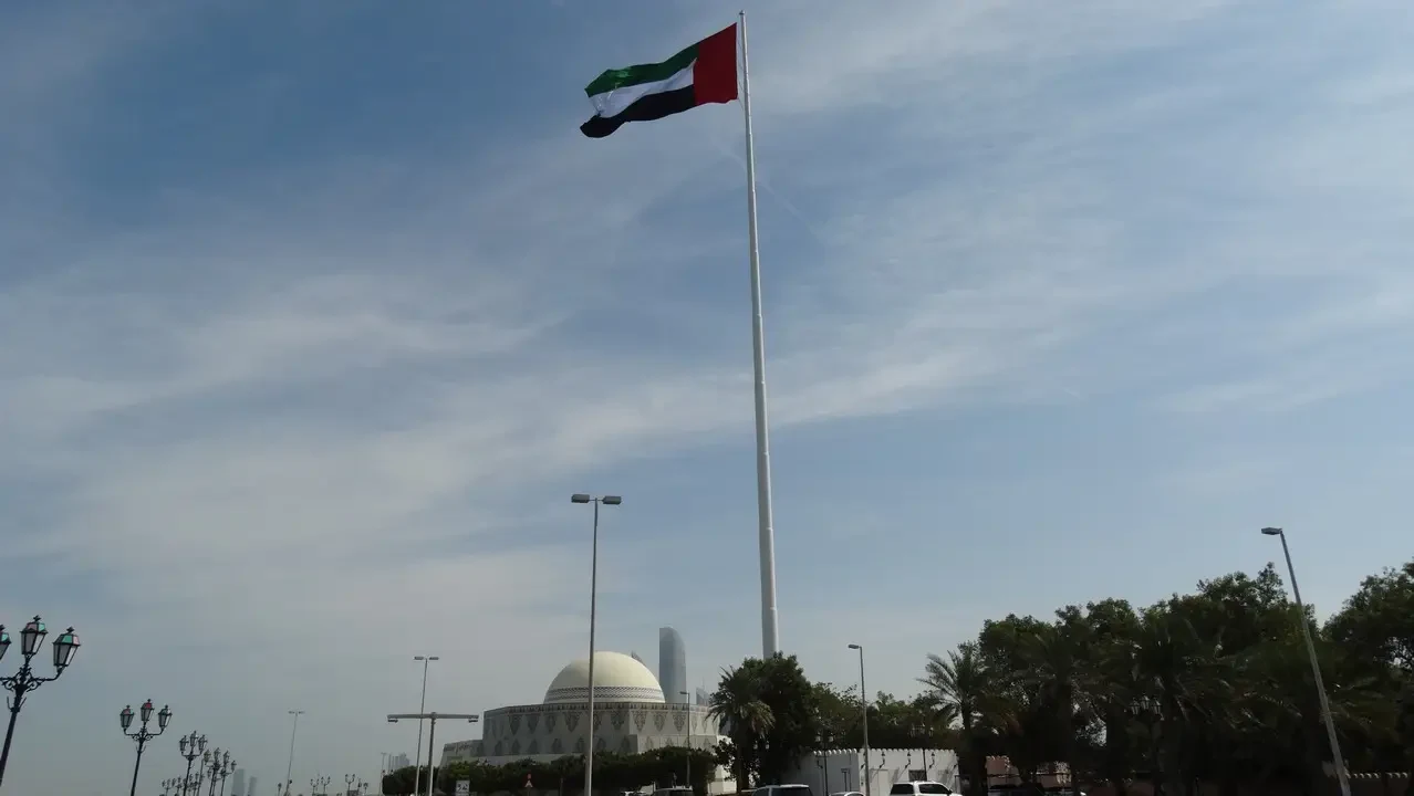 Bandiera degli Emirati Arabi Uniti sventolante sopra un edificio.