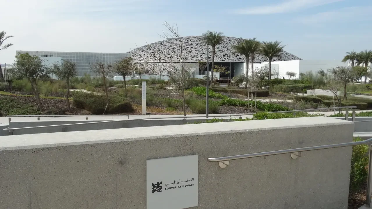 Esterno dell'Abu Dhabi Louvre con paesaggio circostante.