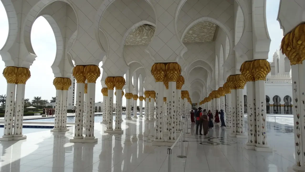 Interno del maestoso Grande Moschea di Abu Dhabi con archi decorati in oro.