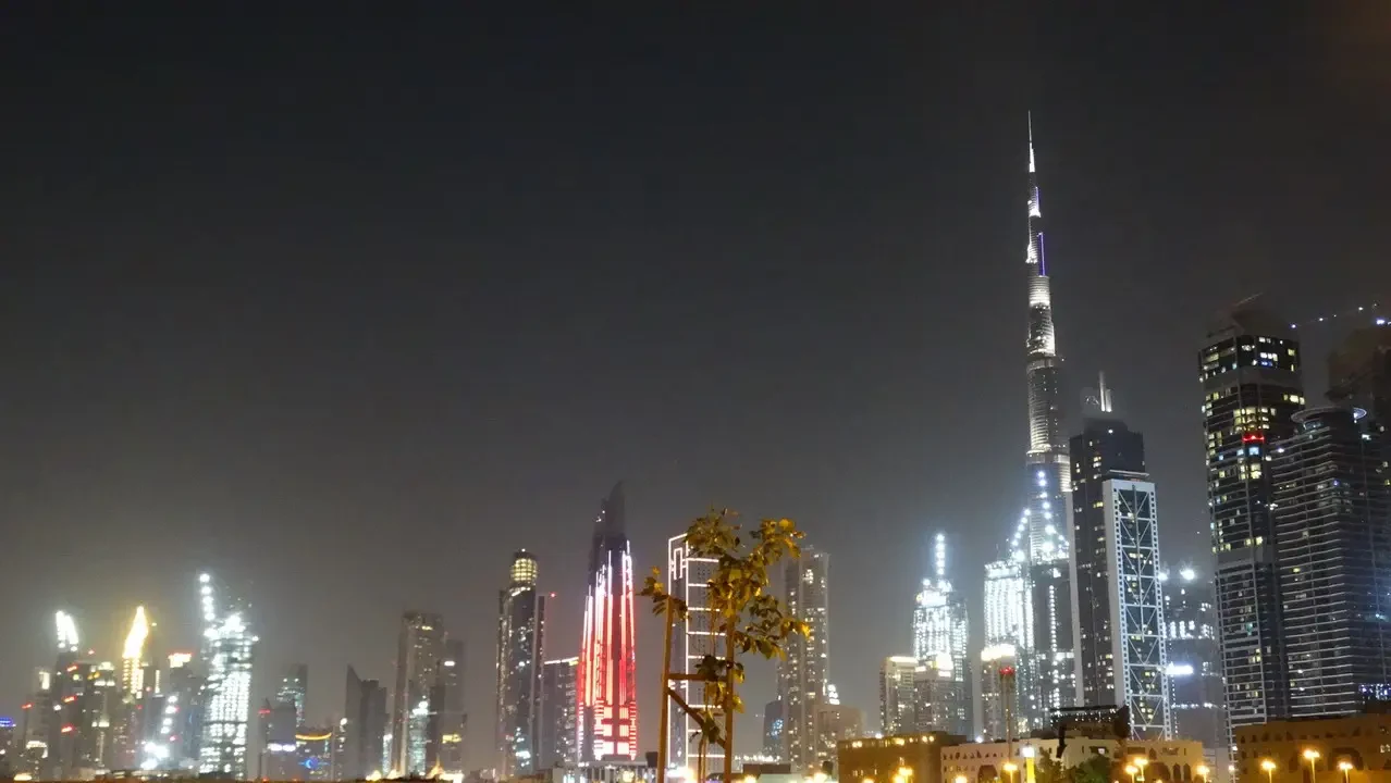 Veduta notturna dello skyline moderno con grattacieli illuminati di una città.