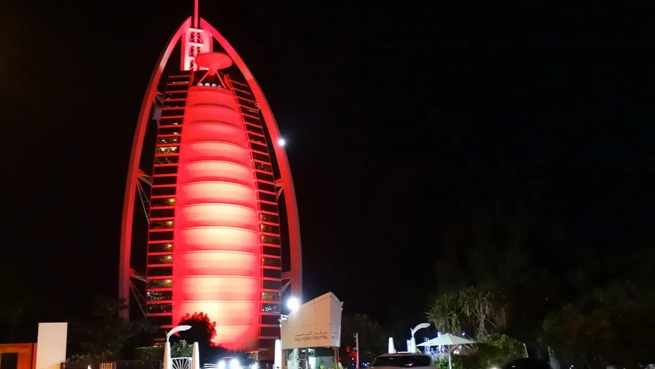 Il Burj Al Arab è illuminato di rosso di notte a Dubai.