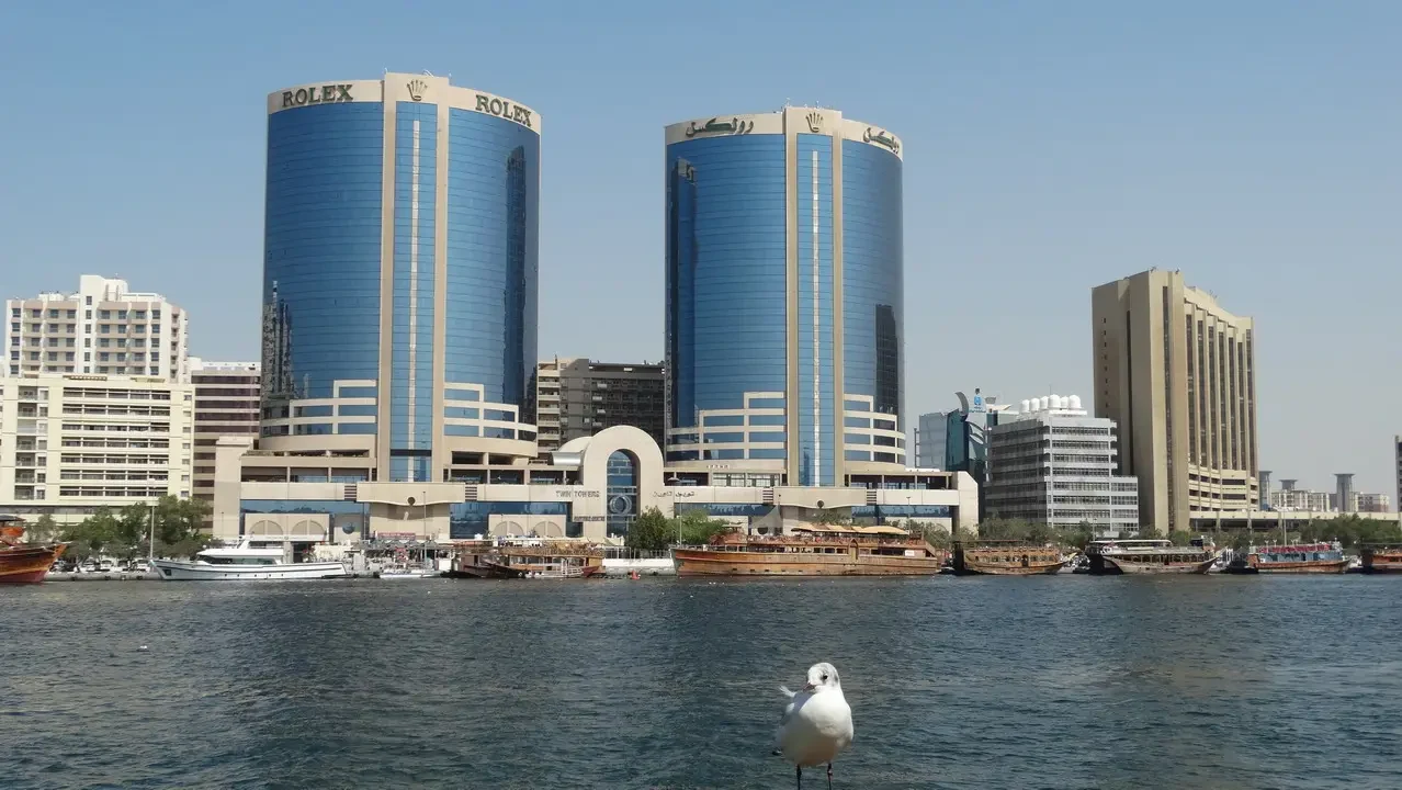 Un panorama di edifici moderni lungo una via d'acqua in un contesto omanita o emiratino.