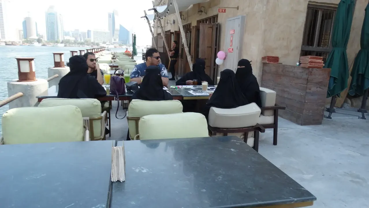 Una veduta del quartiere storico di Dubai con persone sedute all'aperto.