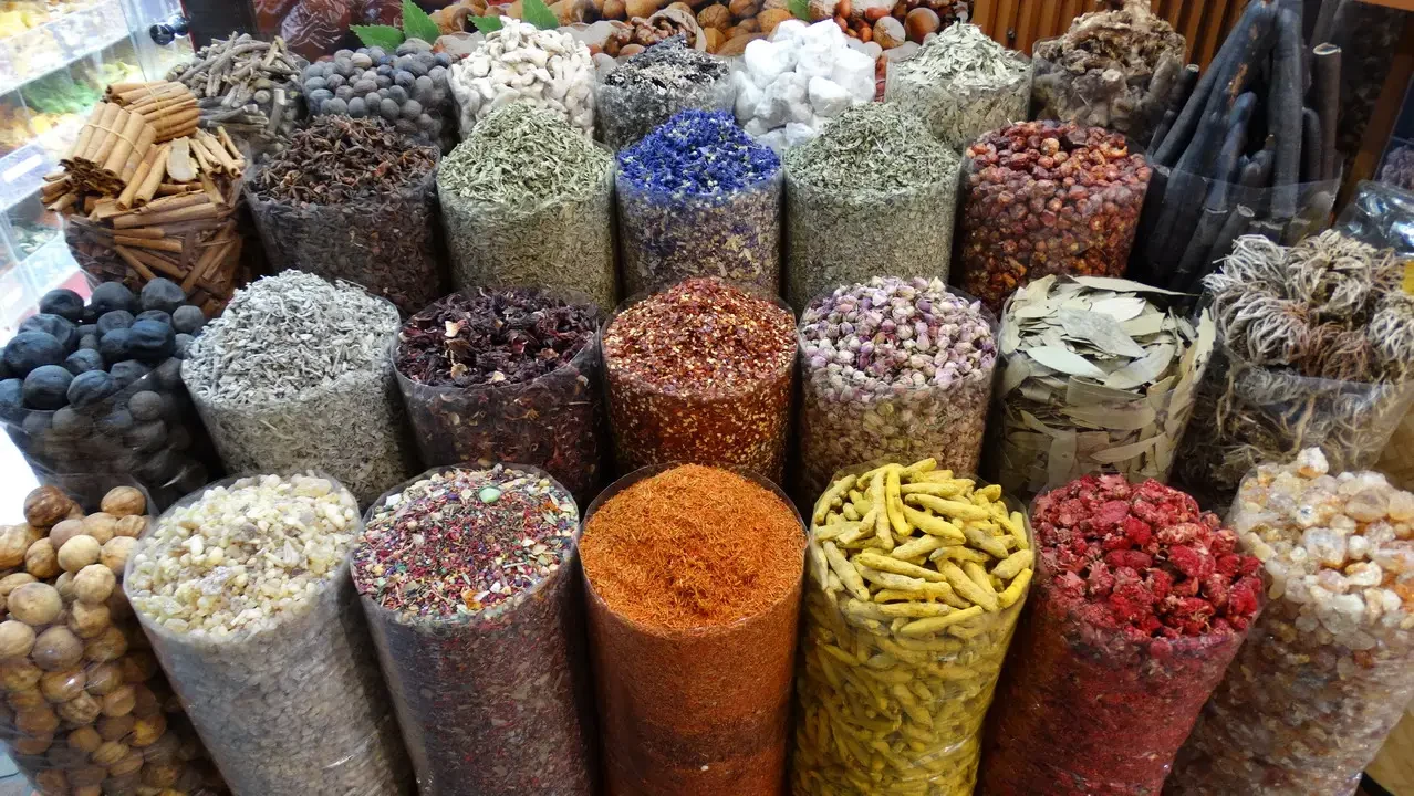 Una galleria di spezie colorate è esposta in una bancarella.
